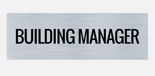 A rectangular metal sign with the words 'BUILDING MANAGER' in bold black letters.