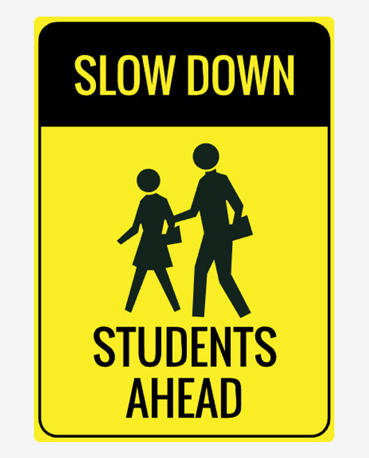 A yellow sign with black text and graphics depicting two stylized students and the phrases 'SLOW DOWN' and 'STUDENTS AHEAD'.