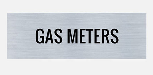 A metal sign with the words 'GAS METERS' printed in capital letters, presented in a plain style font on a silver background.