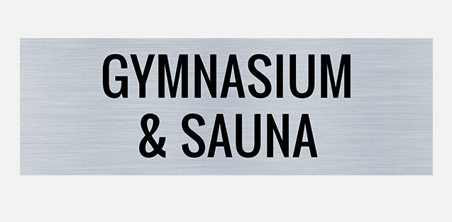 A metal sign with 'GYMNASUM' and 'SAUNA' text in black.