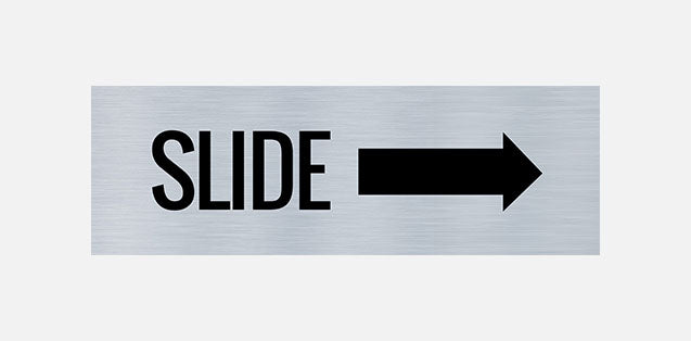 A metal door sign with the text 'SLIDE' printed in bold black letters, indicating a directional instruction to slide right.