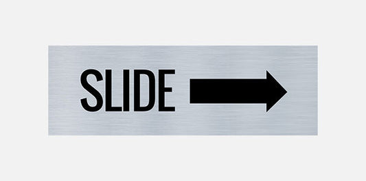 A metal door sign with the text 'SLIDE' printed in bold black letters, indicating a directional instruction to slide right.