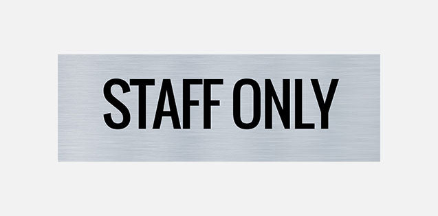 A metal door sign with the text 'STAFF ONLY' printed in capital letters.