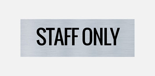 A metal door sign with the text 'STAFF ONLY' printed in capital letters.